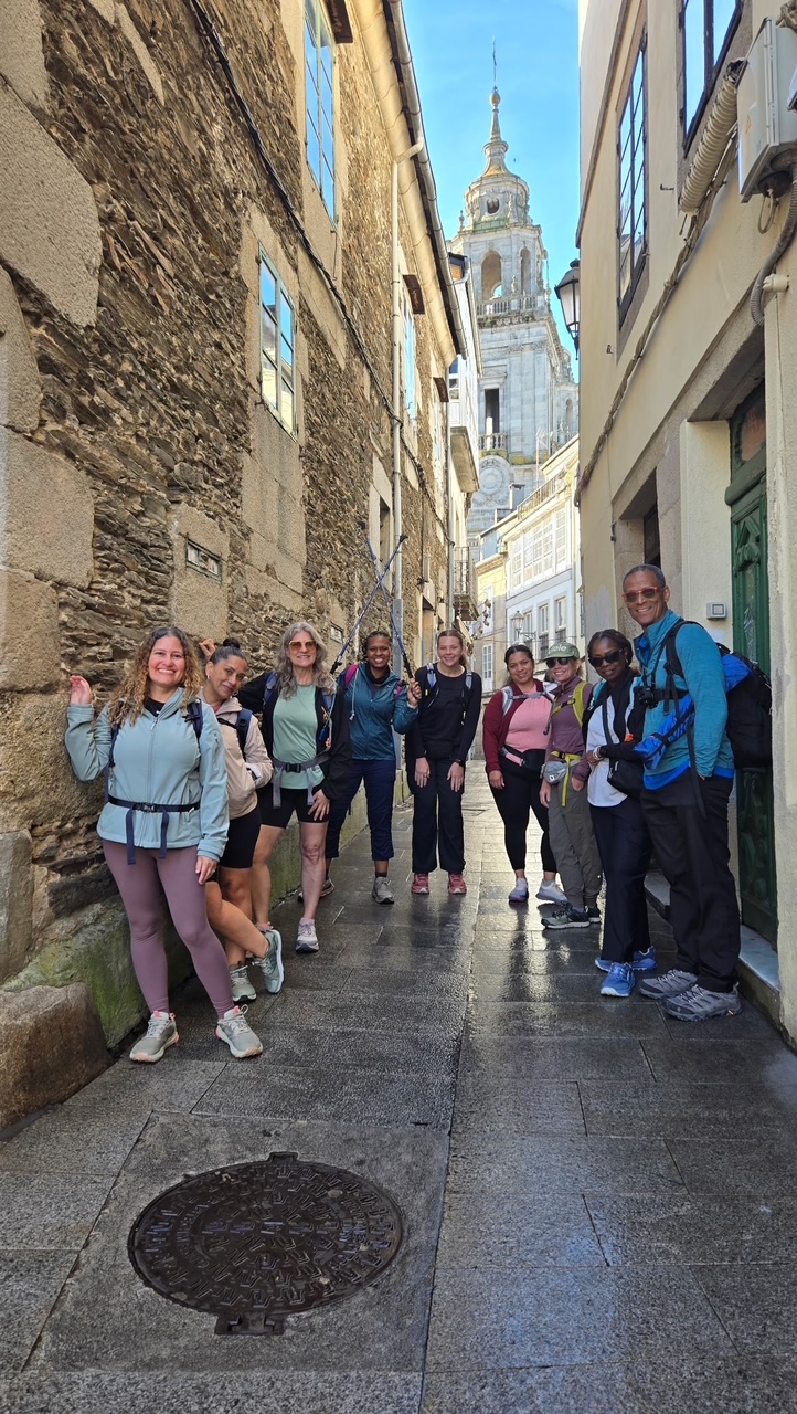 Yasmeen and her trekking group walking a narrow street toward the Cathedral of Santiago