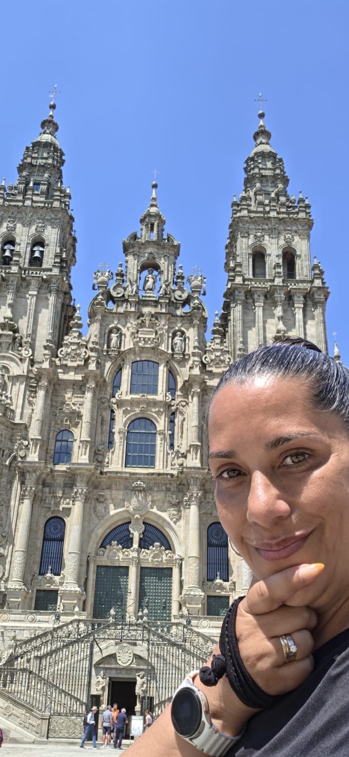 Yasmeen resting in the plaza with the cathedral towers behind her